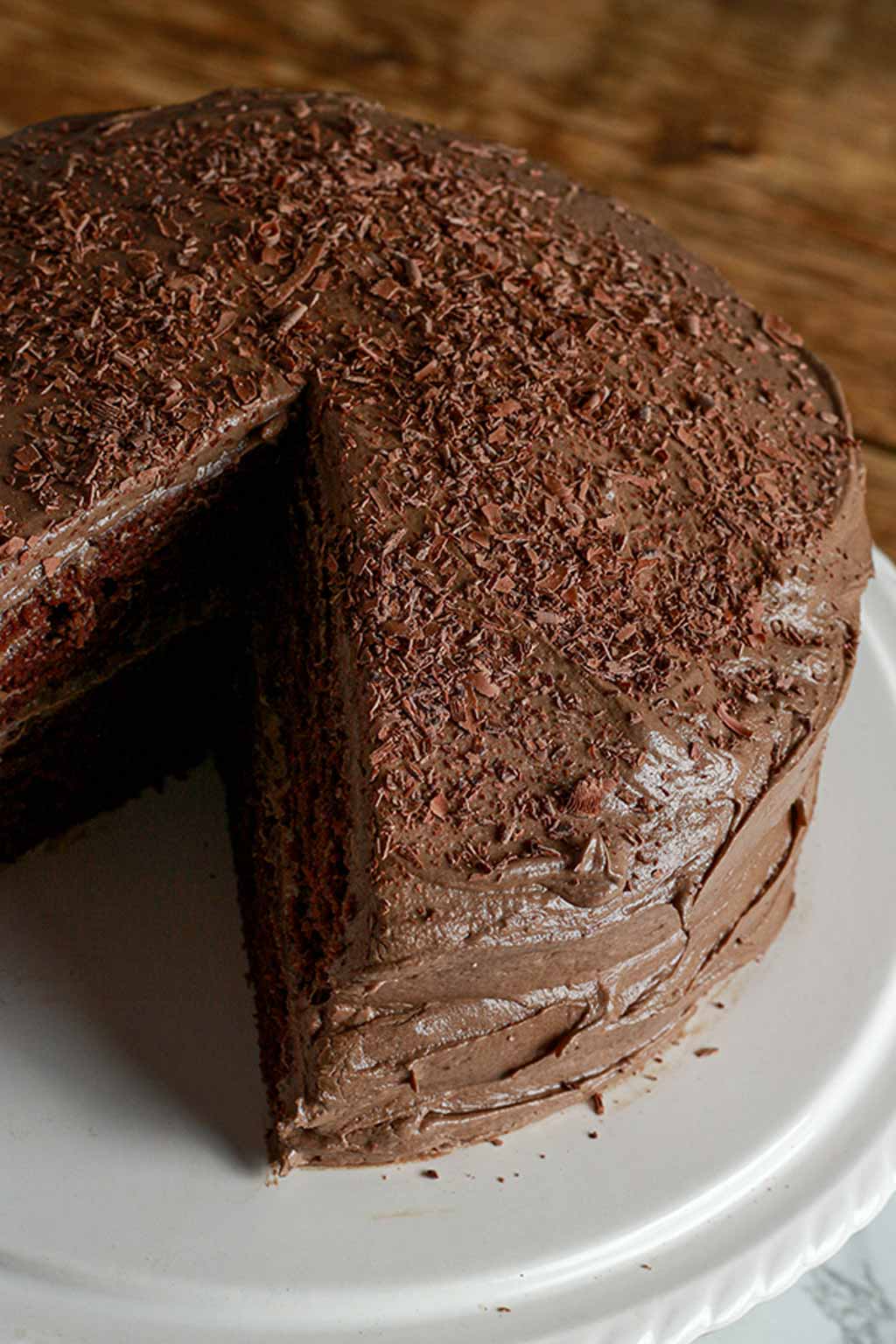  Chocolate Fudge Cake On A White Cake Stand With 1 Slice Missing