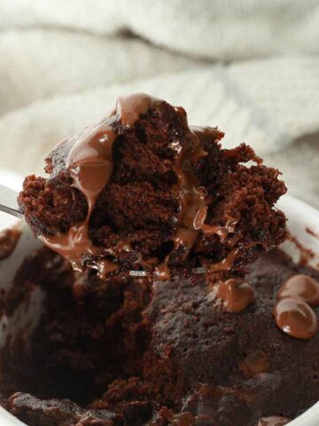 image of a spoonful of chocolate cake being taken out of the mug
