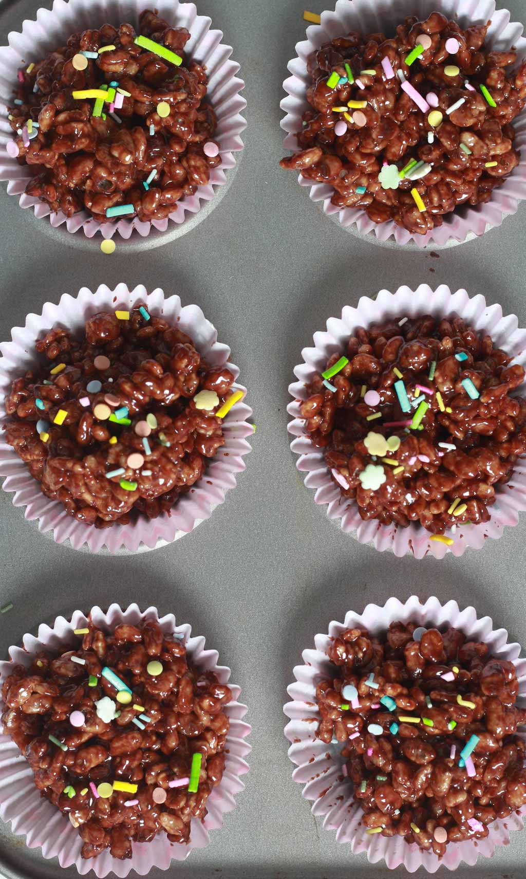 Wet Chocolate Crispy Cakes with sprinkles on top In Cupcake Tin