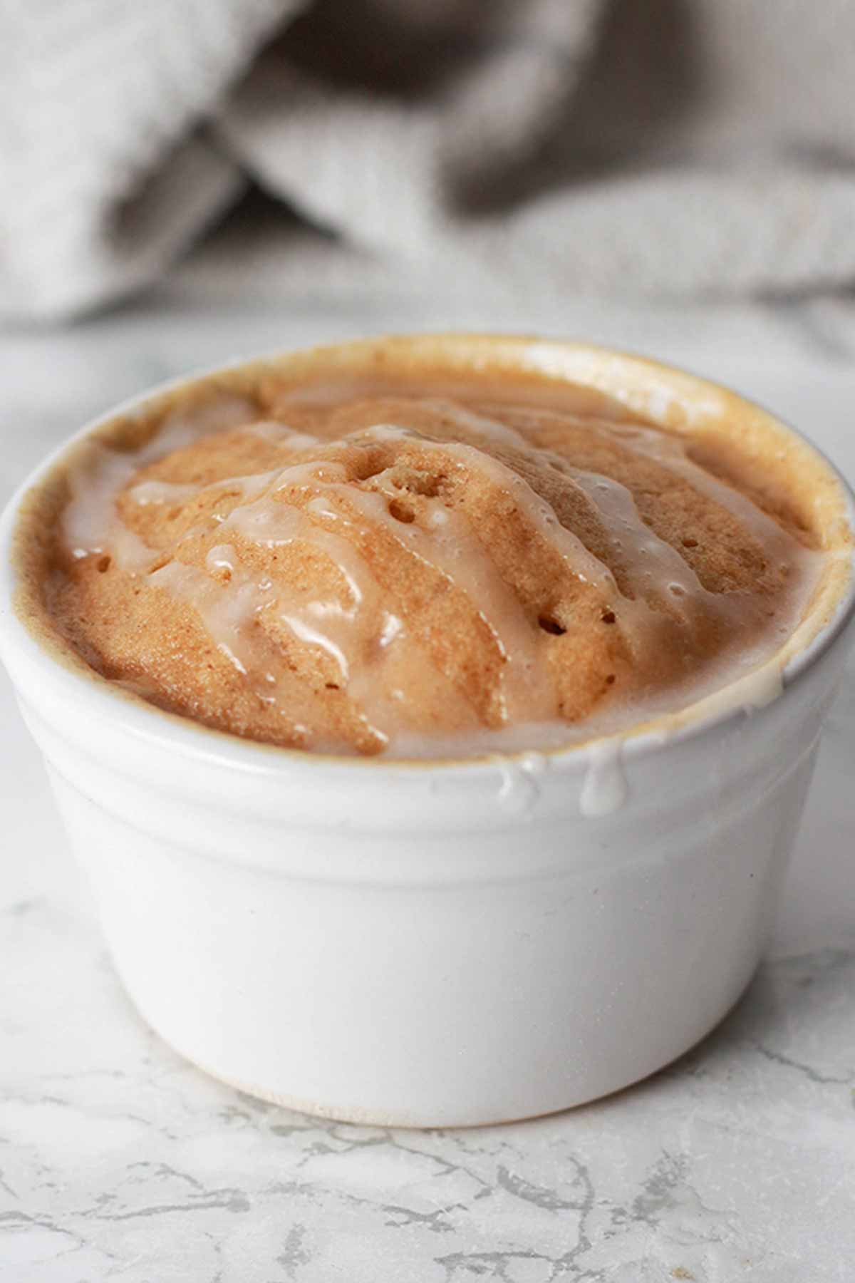 Gingerbread Cake In A White Ramekin With Icing On Top