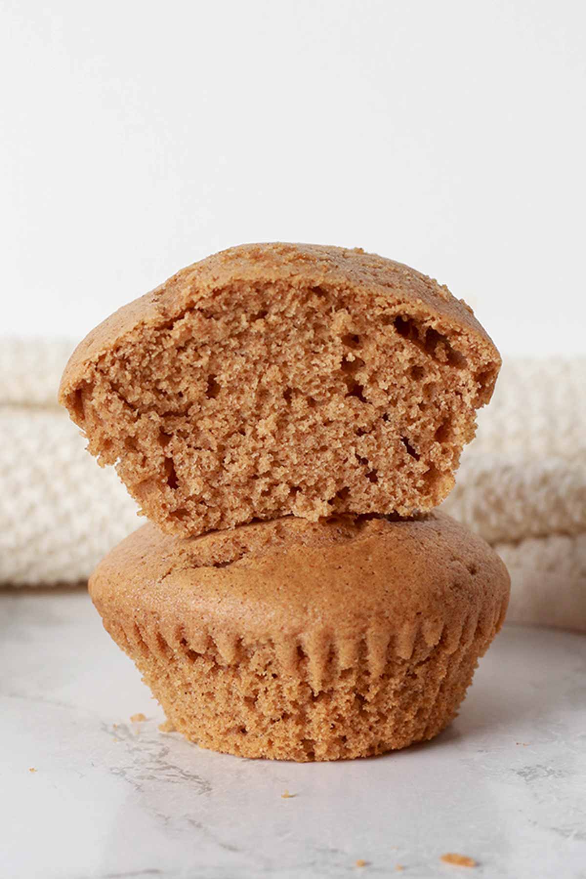 Two Cinnamon Muffins Stacked On Top Of One Another