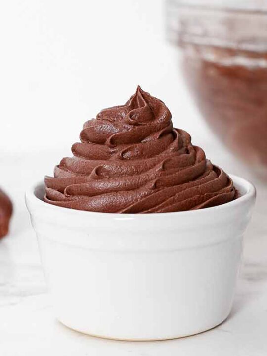 Image of dairy-free chocolate buttercream frosting piped into a white ramekin