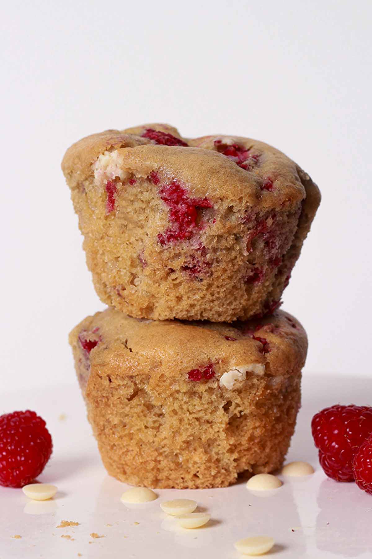 2 Vegan Raspberry White Choc Muffins Stacked On Top Of One Another