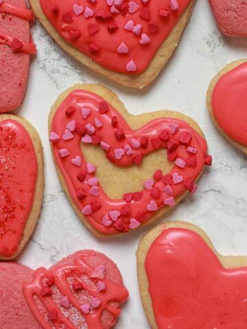 Vegan valentine heart shaped cookies on a white surface