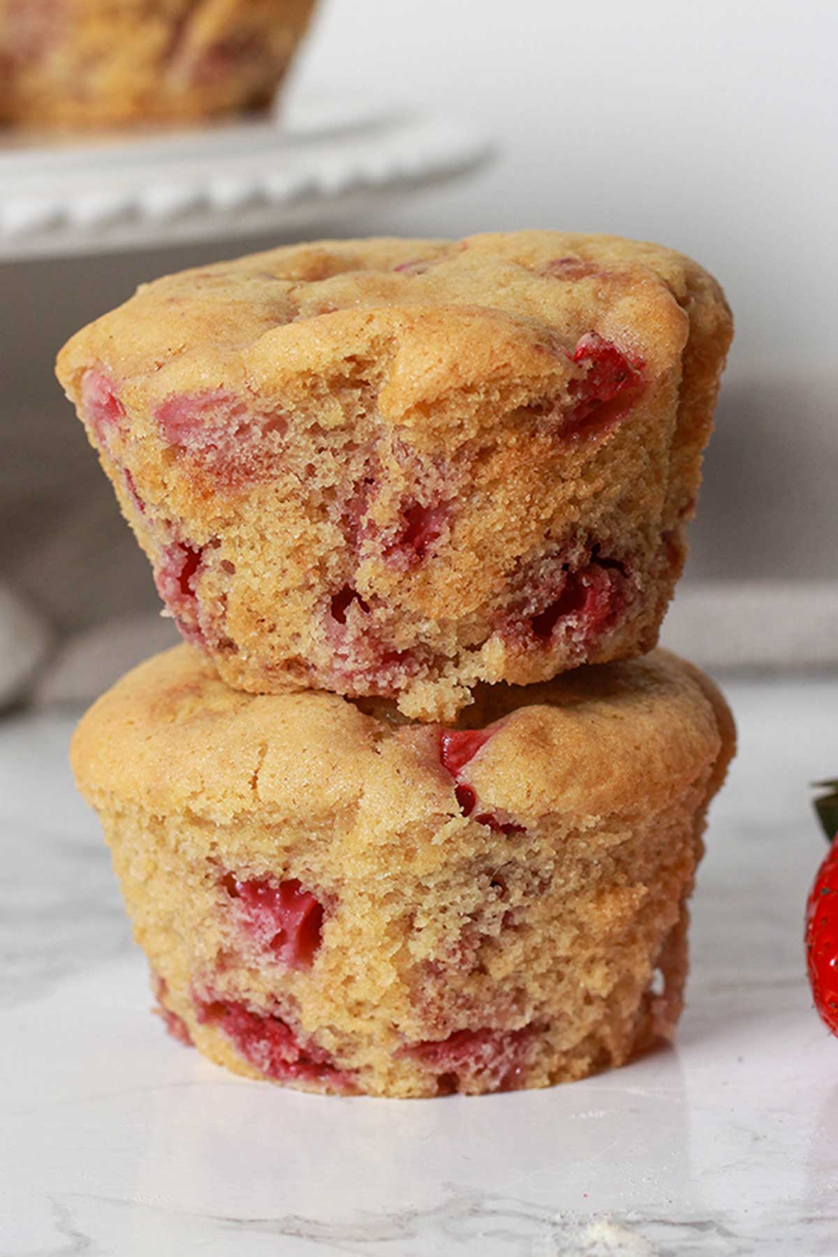 Two Vegan Strawberry Muffins Stacked On Top Of One Another