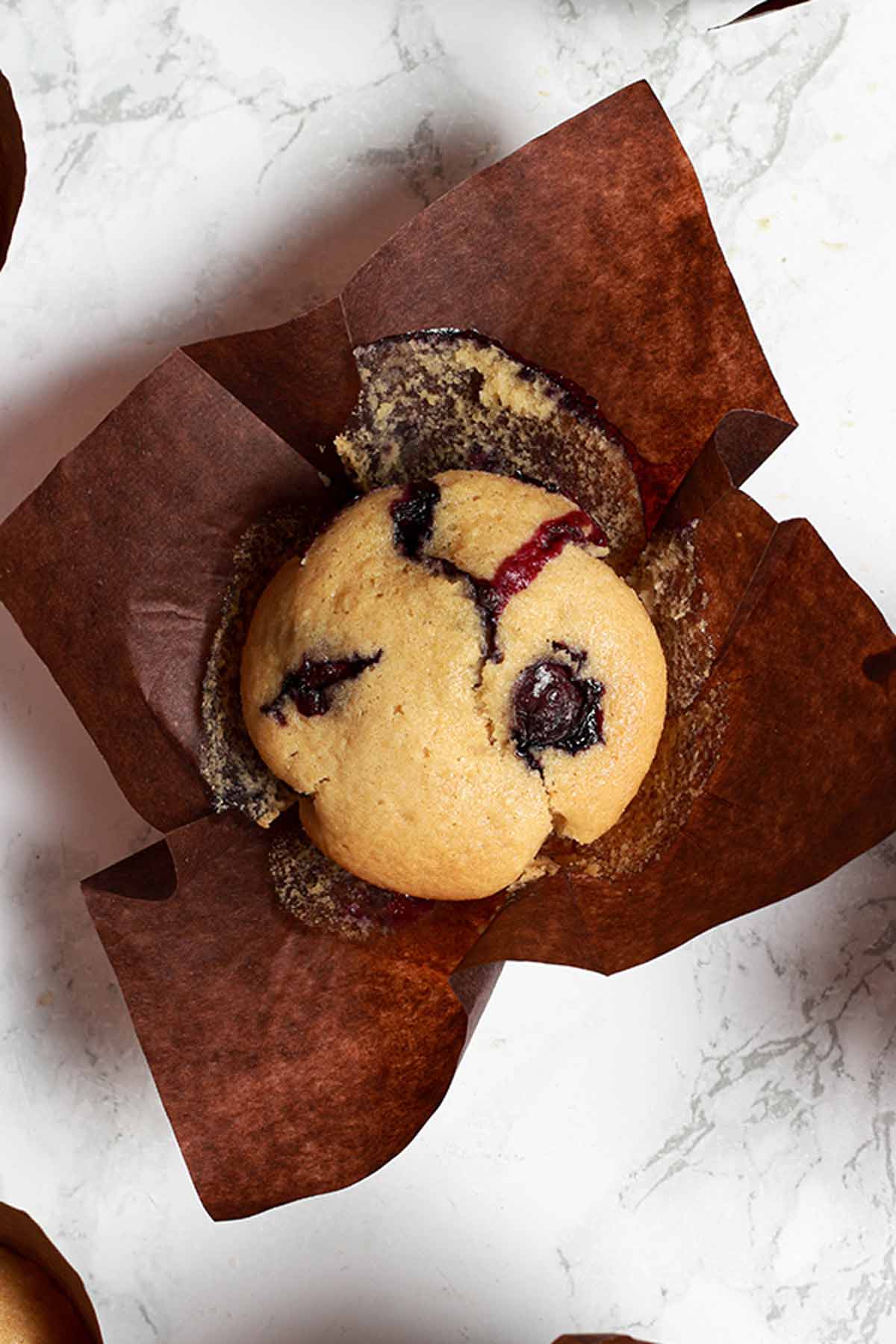 Overhead Image Of Blueberry Muffin In Brown Paper Case