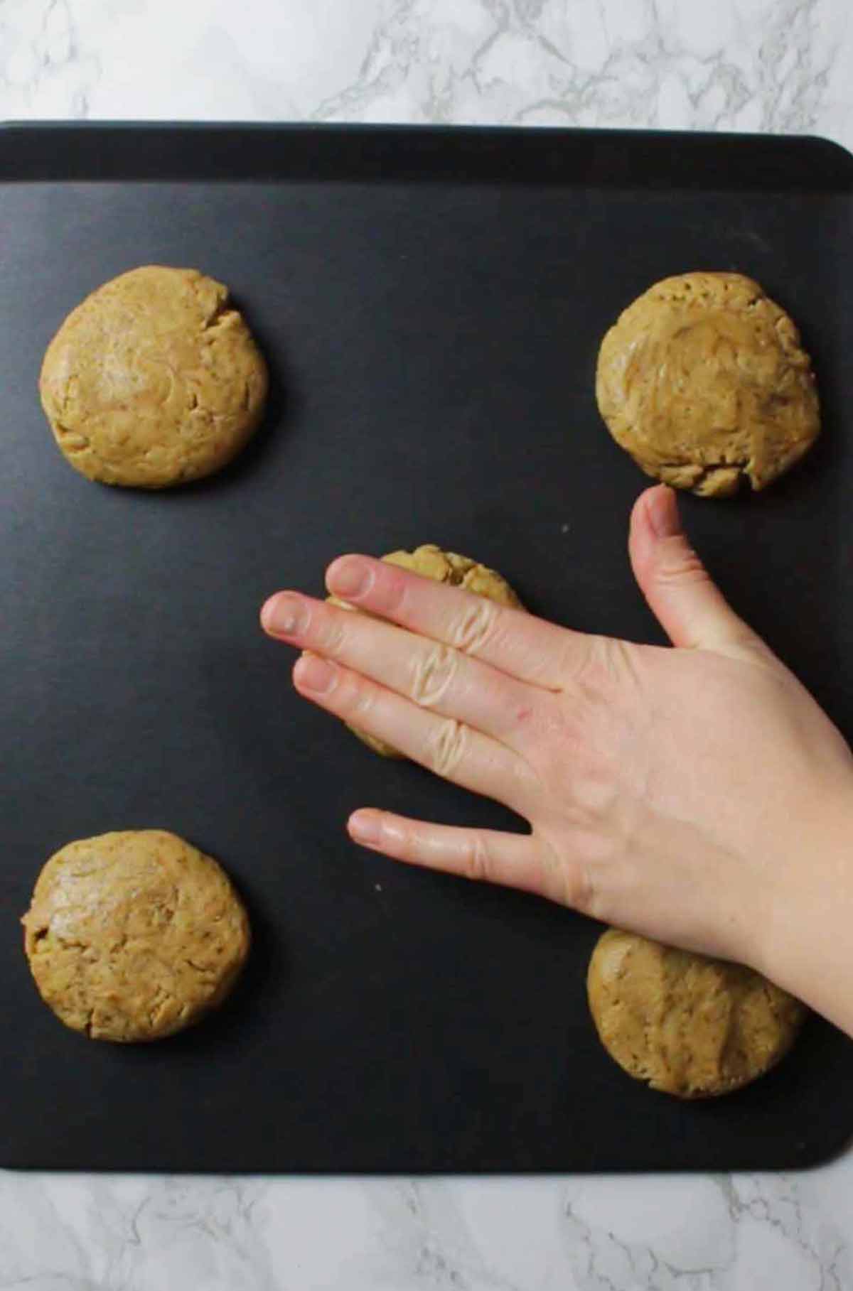 Pressing The Cookie Dough Down Onto The Tray