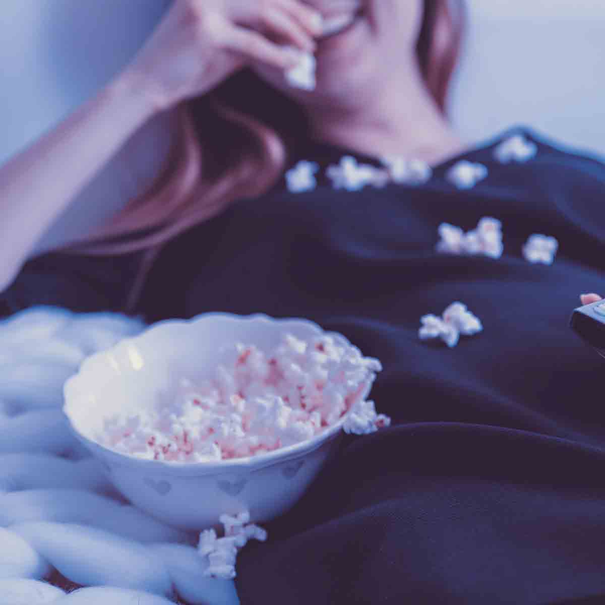 Woman Eating Popcorn And Smiling
