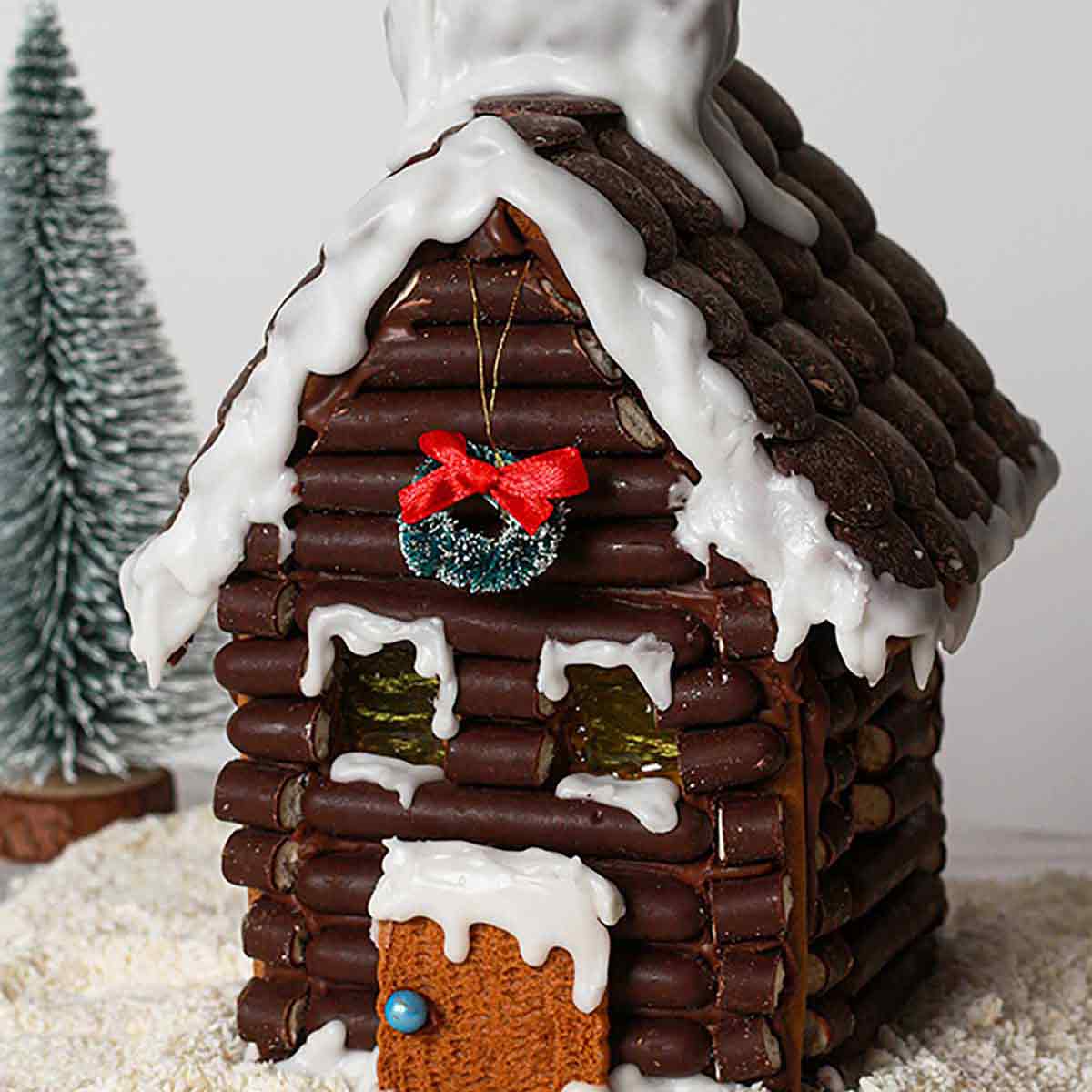 Chocolate Vegan Gingerbread House With A Snowy Background.