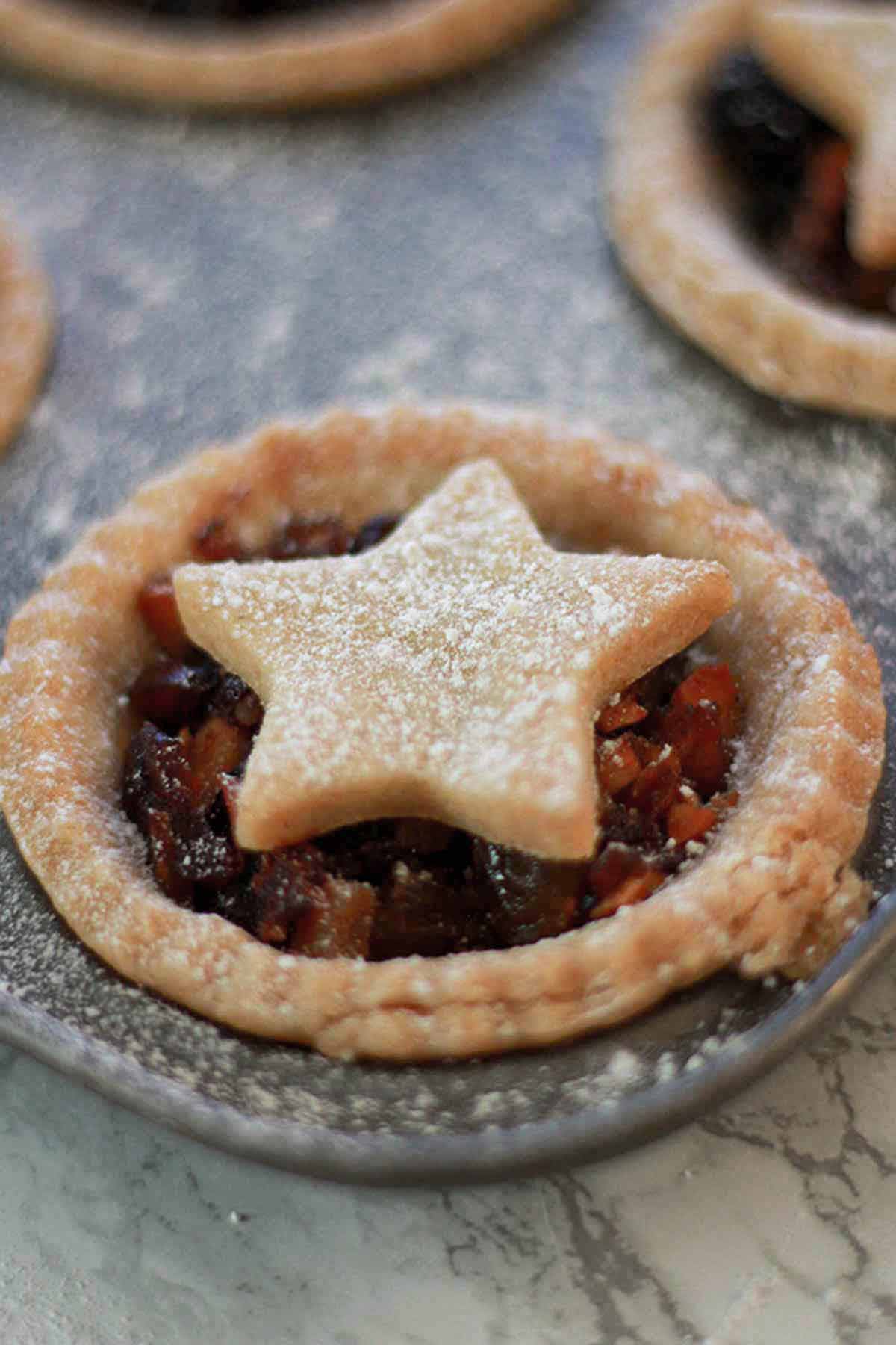 Image Of Dairy-free Mince Pie In The Tin Covered With Icing Sugar