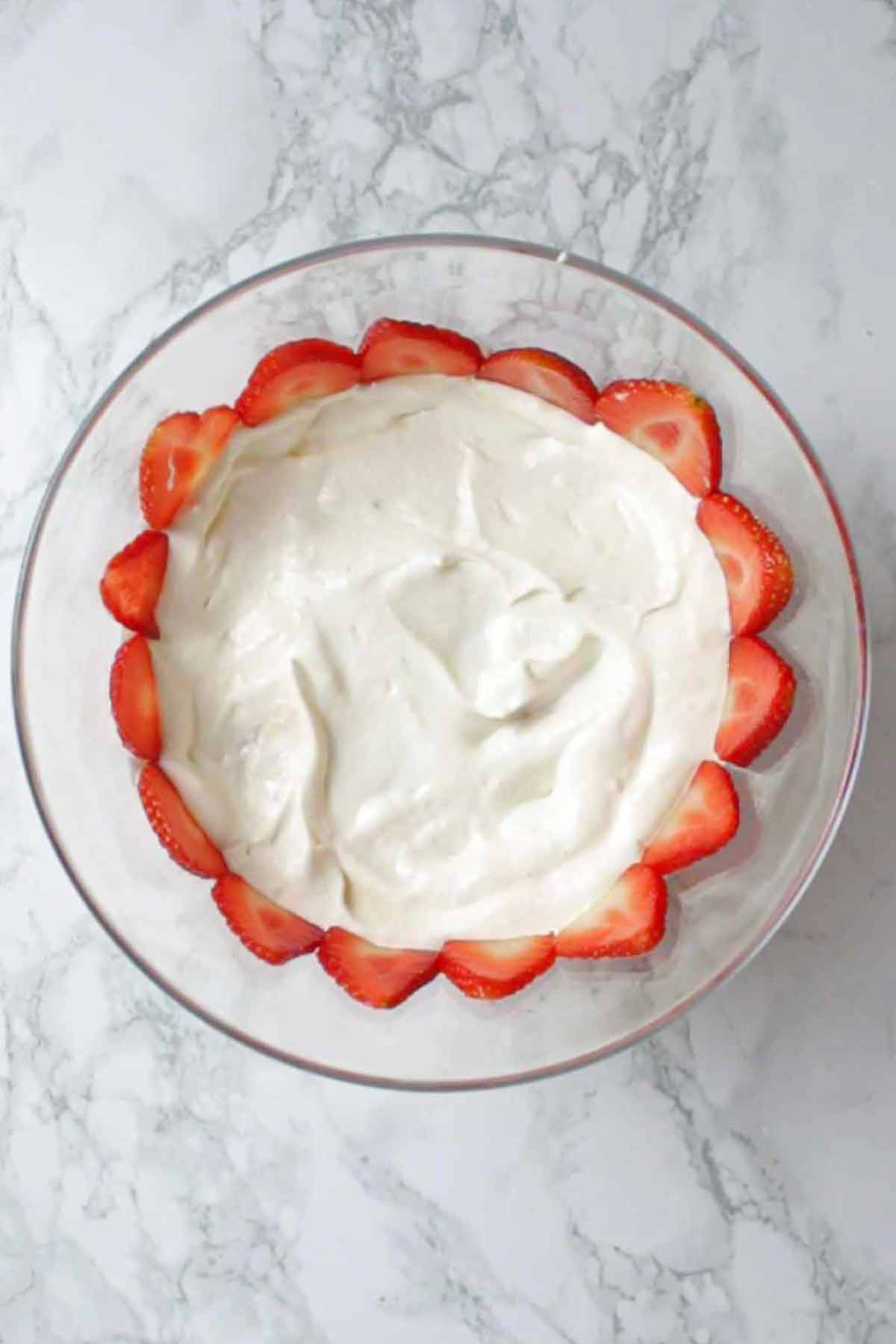 Layer Of Sliced Strawberries and dairy-free cream On The Side Of The Bowl 
