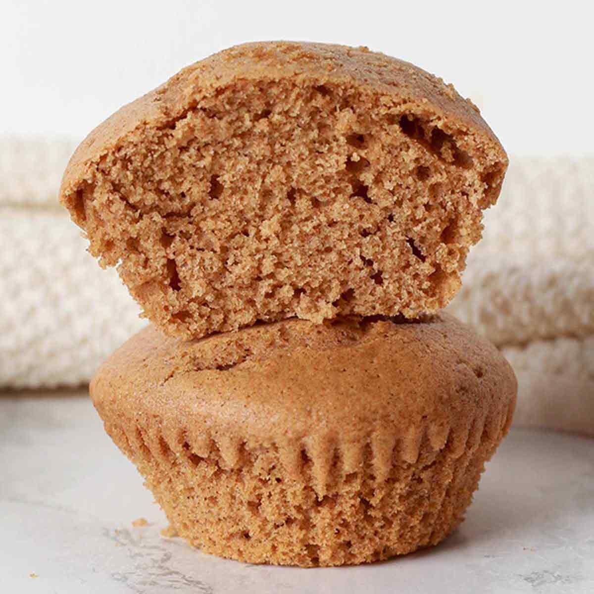 Two Vegan Cinnamon Muffins Stacked On Top Of One Another