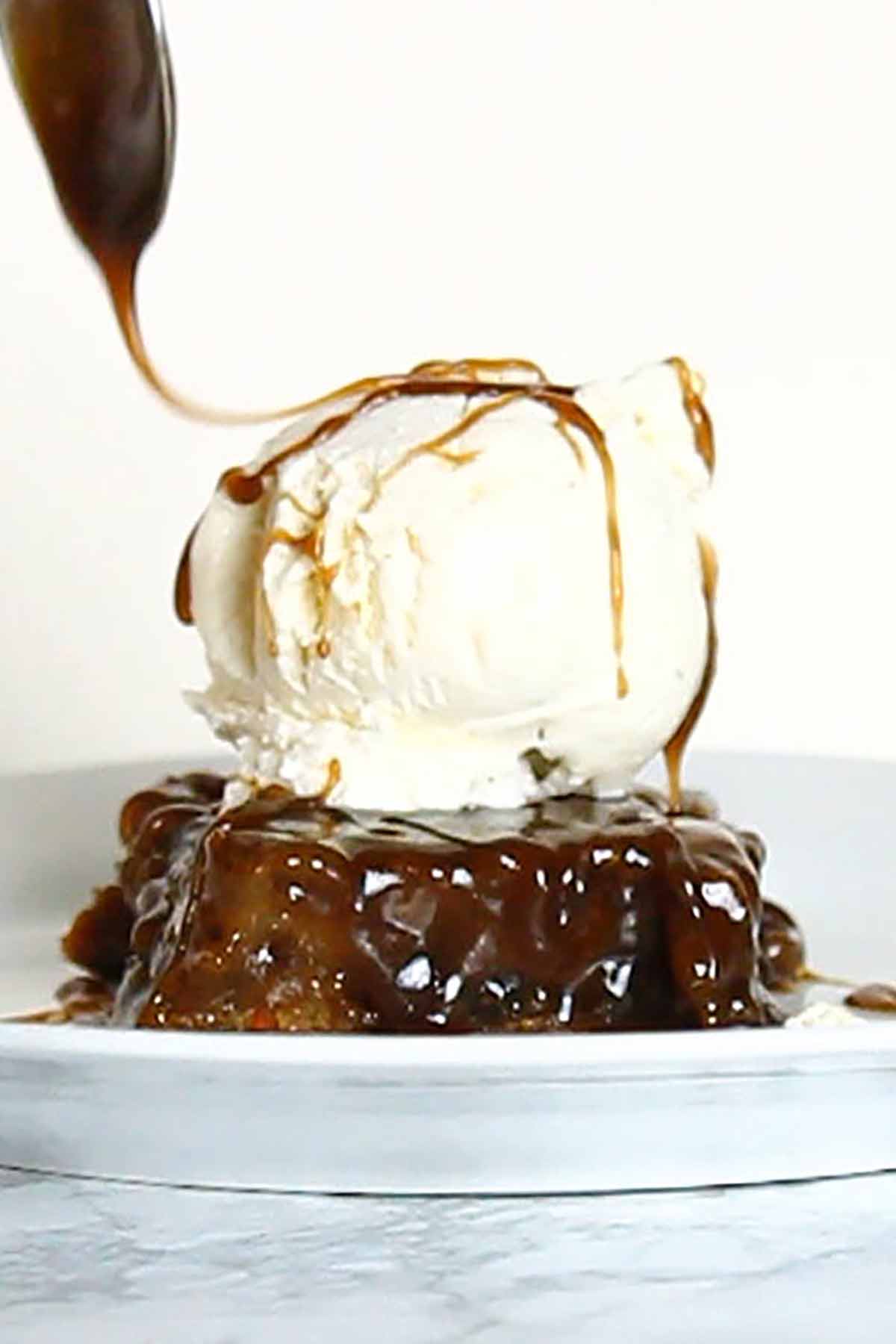Vegan Sticky Toffee Pudding With Sauce Being Swirled On Top