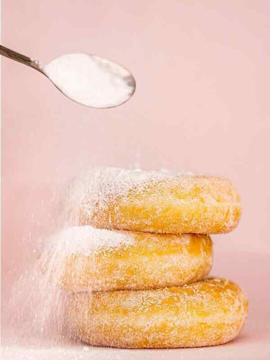 Pouring Sugar Onto Donuts