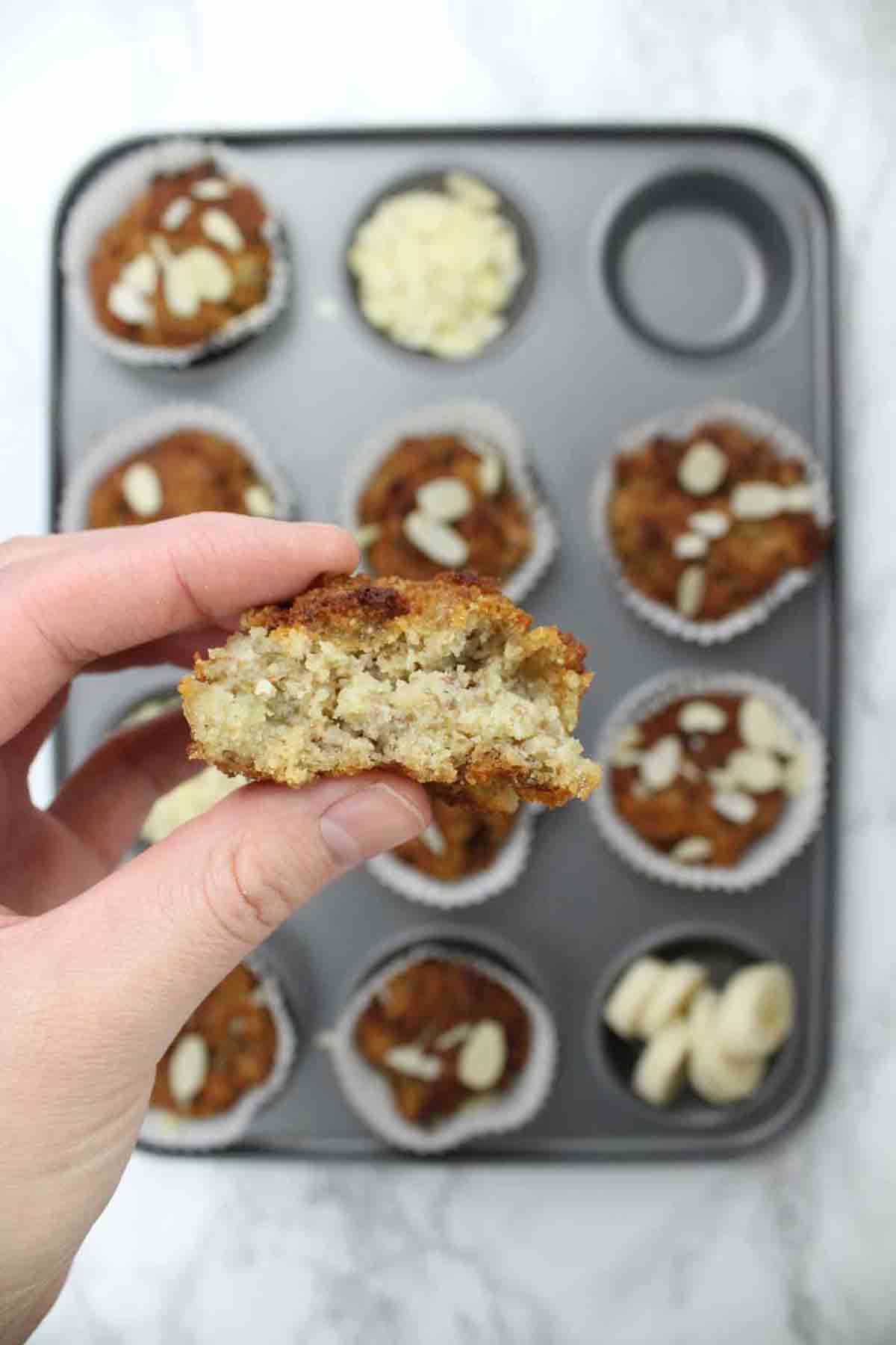 A Hand Holding Half Of A Muffin