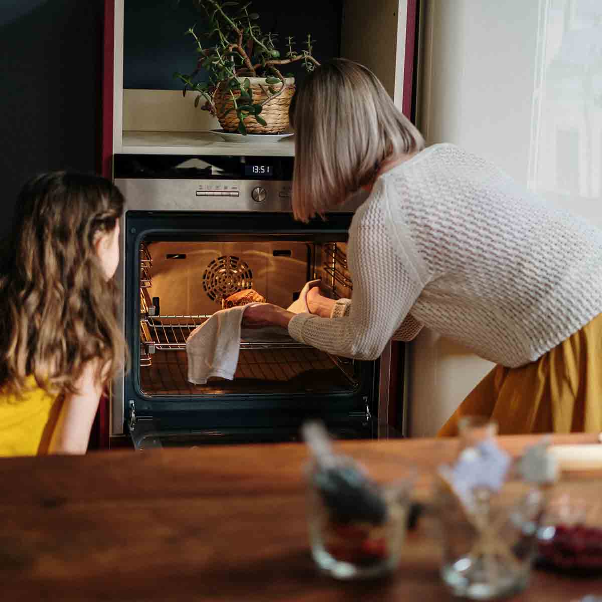 A Woman Removing Something From The Oven