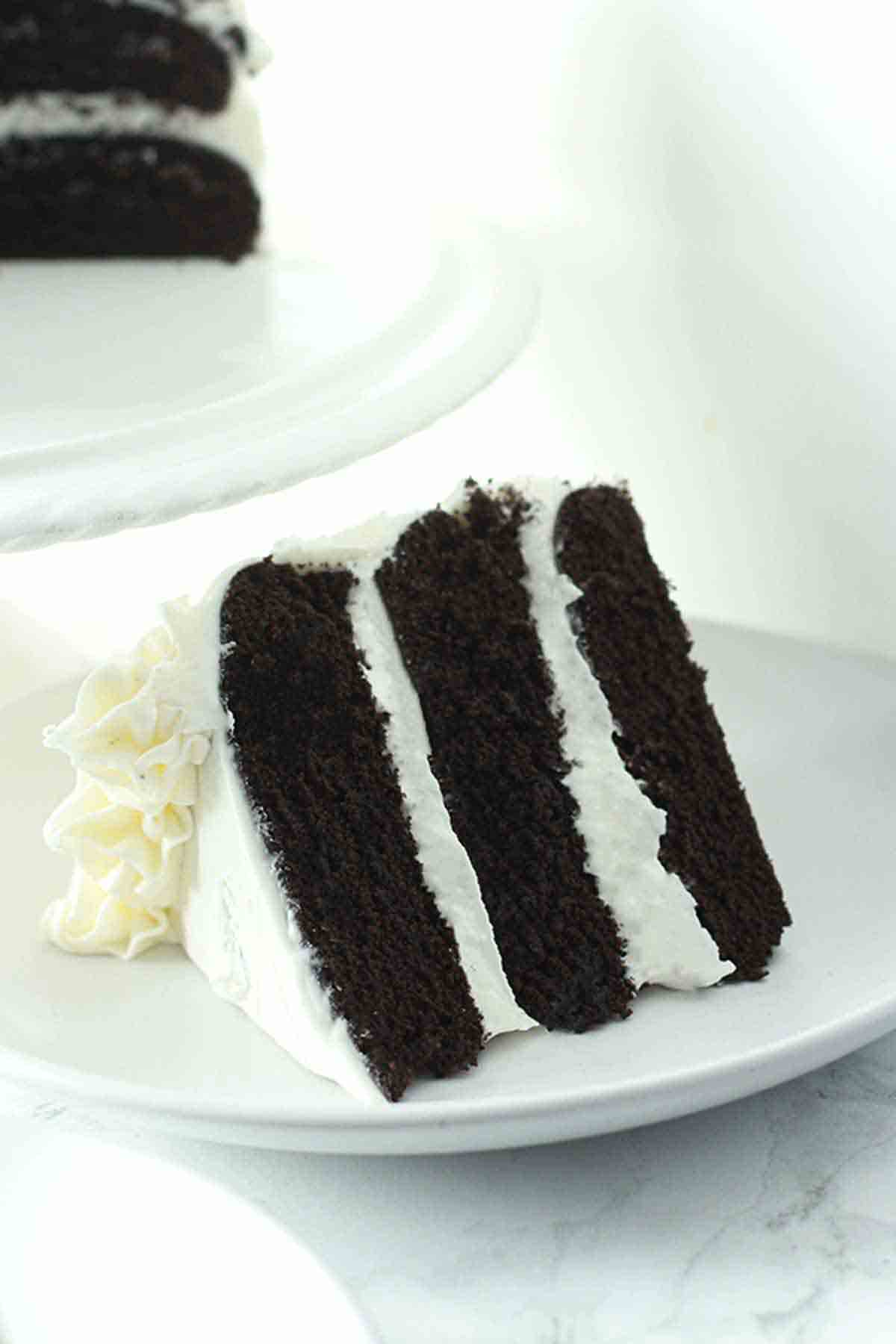 Slice Of Eggless Black Velvet Cake On A White Plate