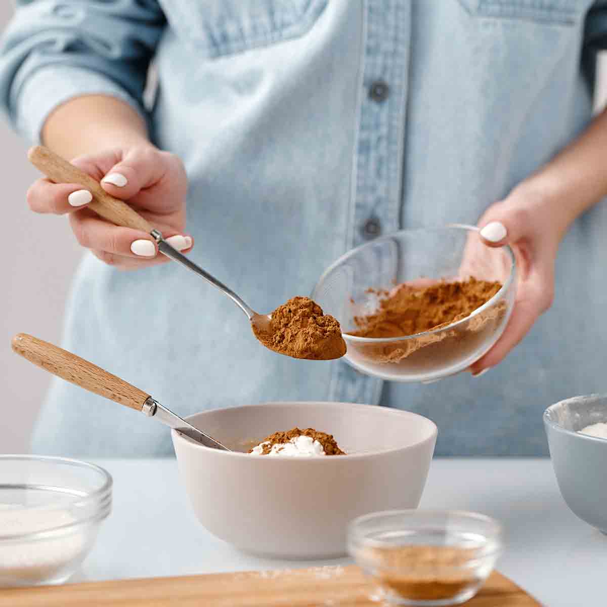 A Woman Placing Vegan Cocoa Powder Into A Bowl