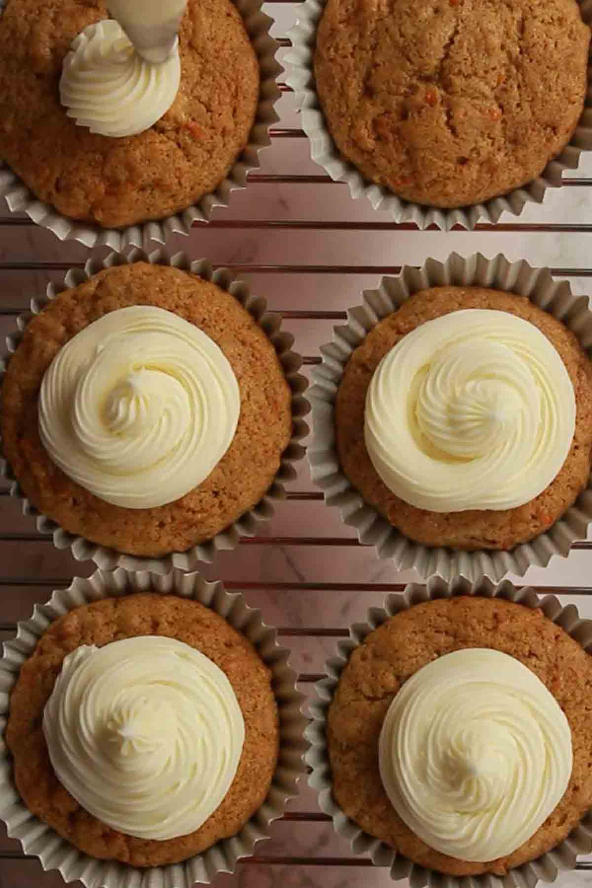 Carrot  Cake Cupcakes Being Icing With Buttercream