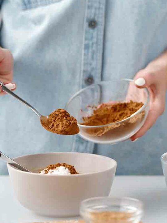 Is Cocoa Powder Vegan Thumbnail Image Of Woman Putting Cocoa Into A Bowl