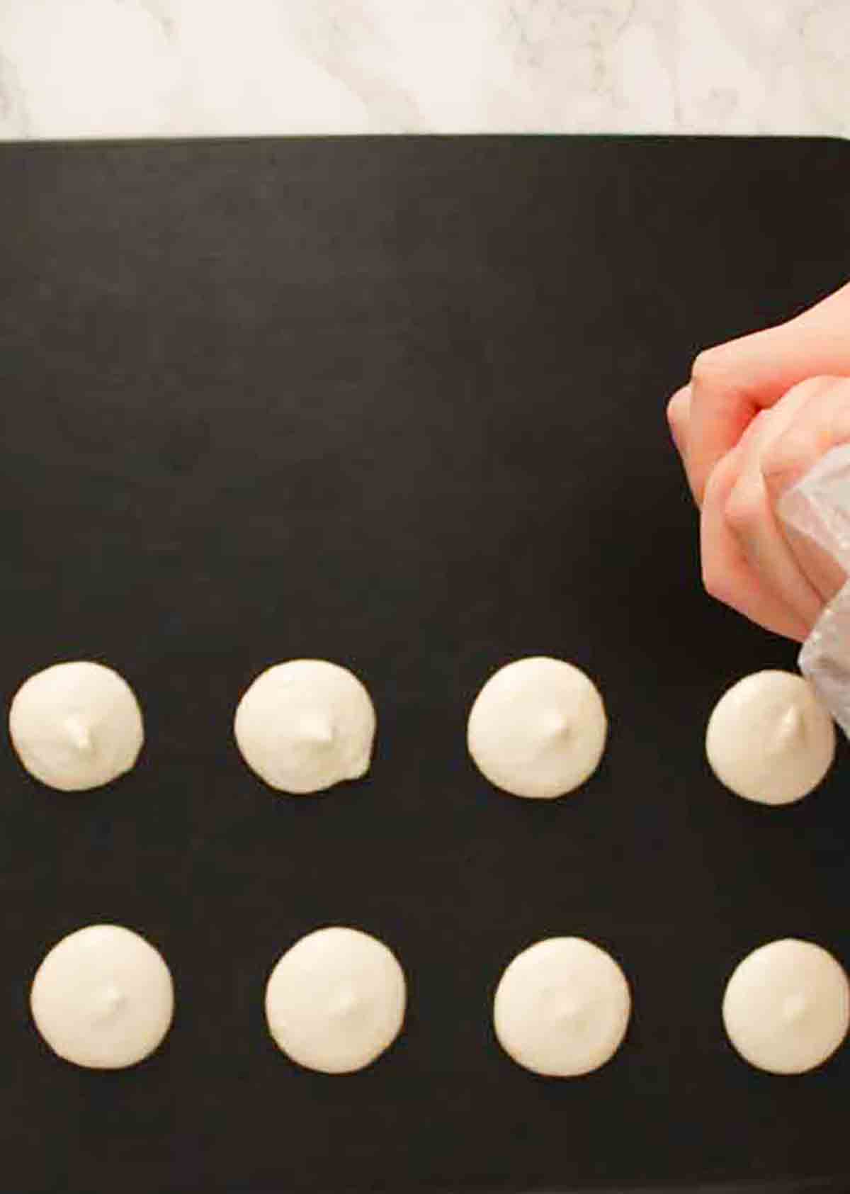 Piping Macaron Mixture Onto Black Tray