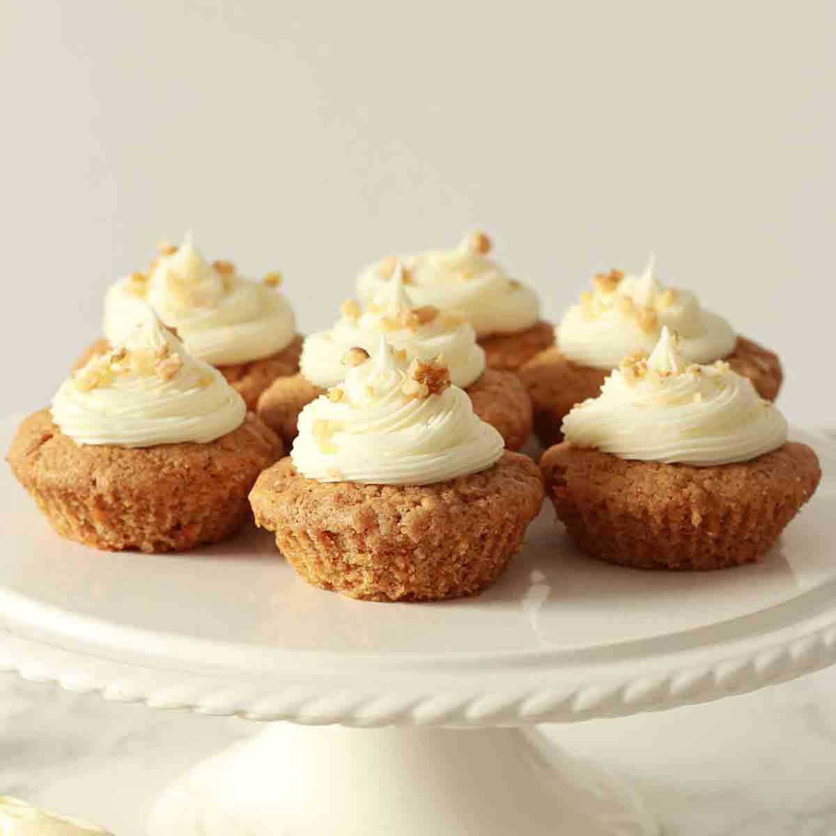 Vegan Carrot Cupcakes On A White Cake Stand