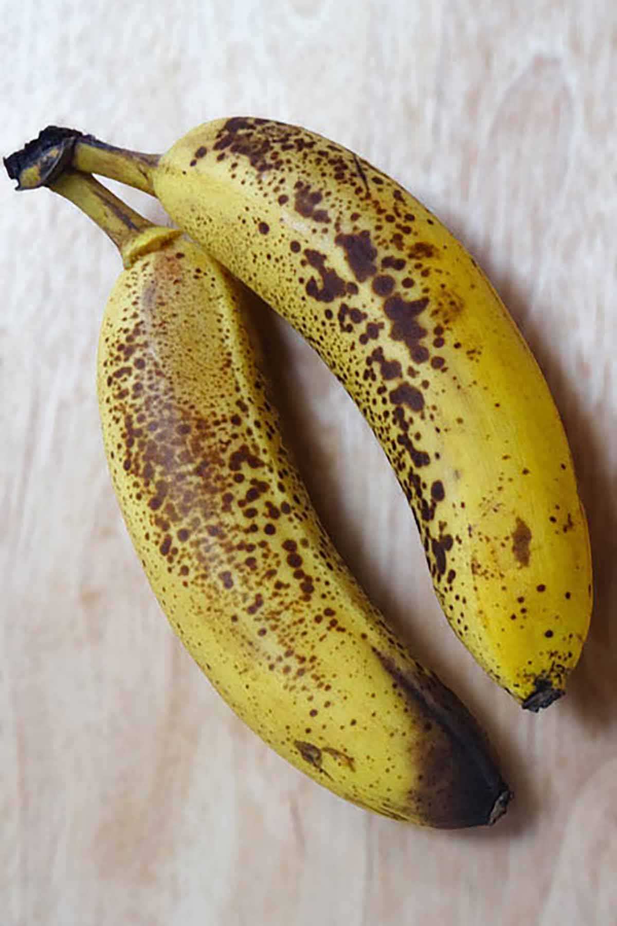 Two Bananas With Brown Spots On Them