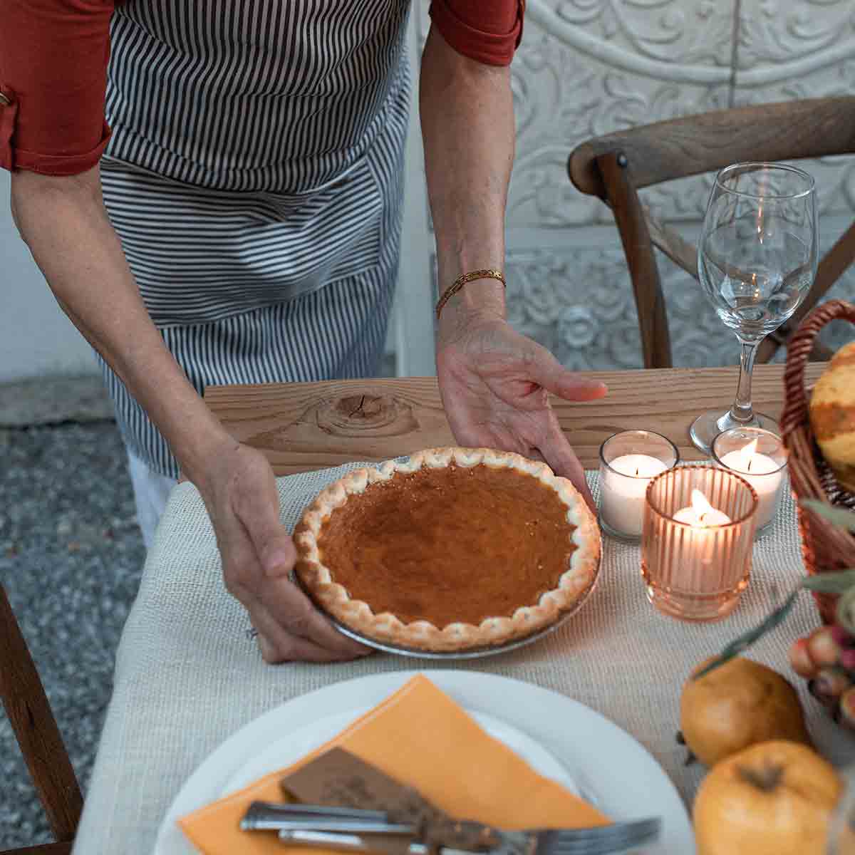 Person Serving Pumpkin Pie At A Table