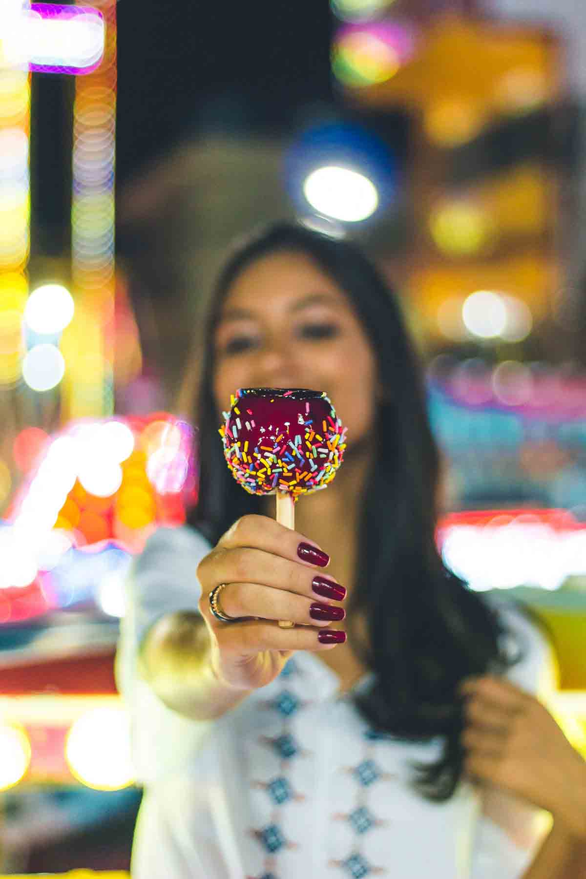 Girl Holding A Toffee Apple With Sprinkles On It