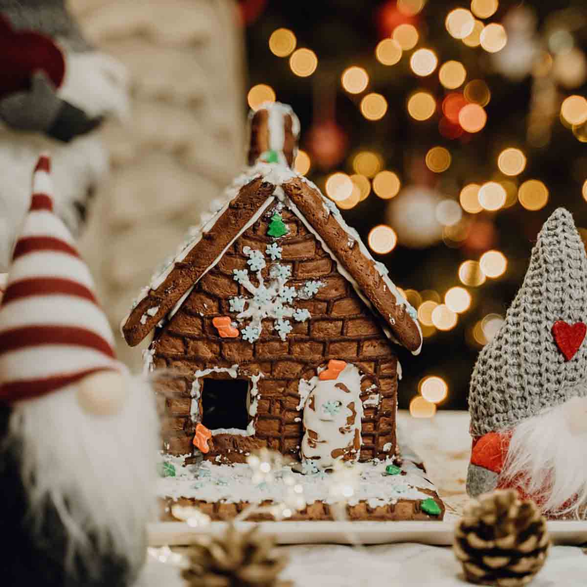 Gingerbread House Surrounded By Christmas Decorations