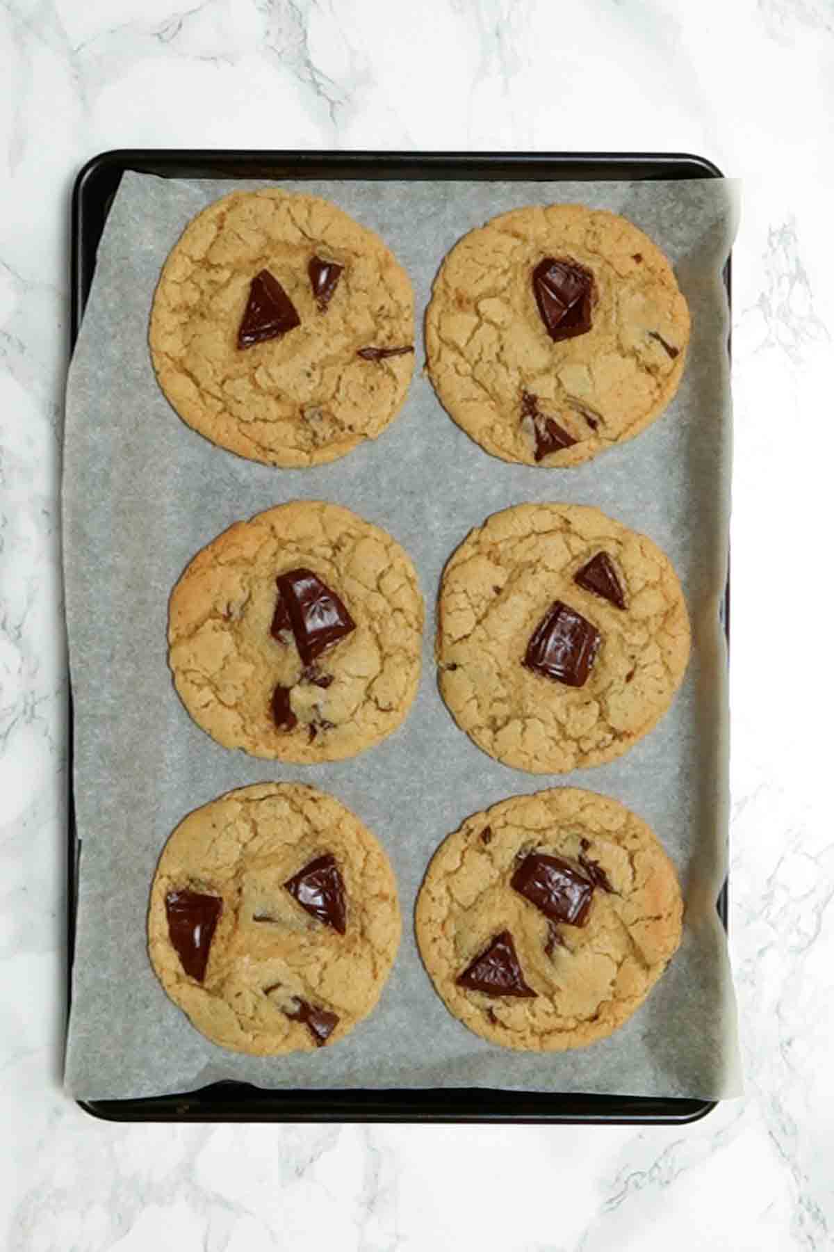 6 Baked Cookies On A Lined Baking Tray